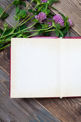 Top view of open book photo album with clover flowers