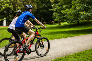 Healthy lifestyle - people riding bicycles in city park