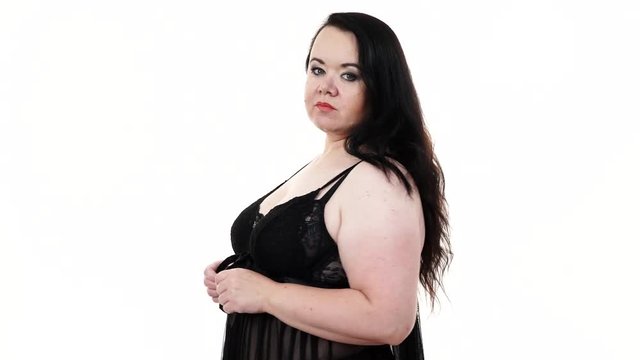 Plus size fat woman wearing black lace lingerie babydoll, positive smiling face expression. Overweight oversized overeating chubby obese model in underwear