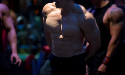 Fototapeta na wymiar Blurred muscular bodybuilder guy in a gym