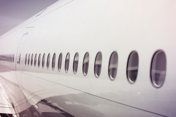 Aircraft (airplane) fuselage, close up view. Reflections on windows.