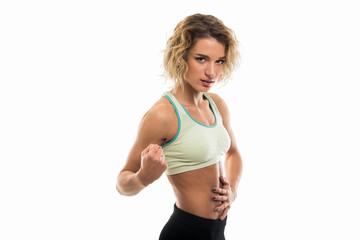 Portrait of fit girl holding abs making strong gesture