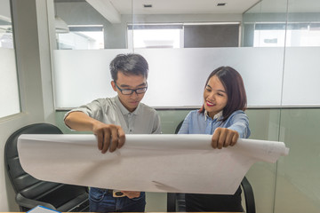 Office lady showing data on project drawing to her colleagues