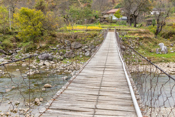 Obraz premium wooden suspension bridge over a river in the mountains, China Shaanxi Province