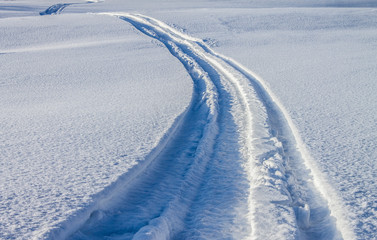 Obraz premium Snowmobile trail in the snow in spring