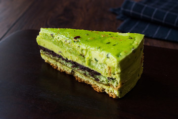 Matcha Green Tea Layer Cake Slice on Dark Wooden Board.