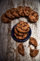 group of tasty cookies next to a bowl on an old wooden board
