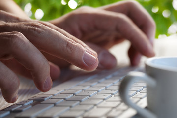 Close-up picture of male hands typing on desktop computer keyboard