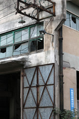 Fototapeta na wymiar Derelict abandoned architectural exterior building setting with old plastic windows and frames with rusty concrete surfaces somewhere in China