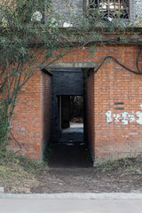 Derelict abandoned architectural interior exterior building setting with old red brick pattern towards main entrance somewhere in China