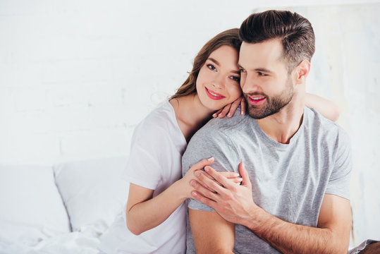 adult happy couple gentle embracing and smiling in bed