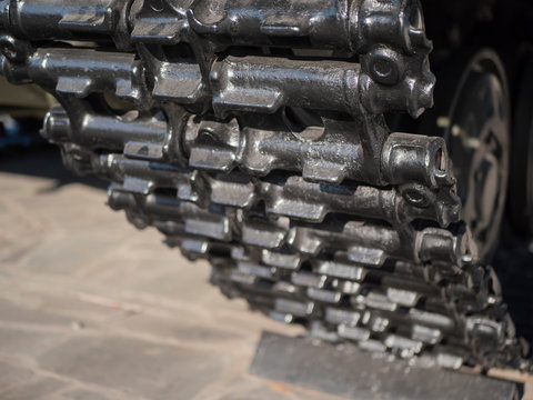 Tank tracks. A tank of the second world war. The Caterpillar Track of a Military Tank. Black track link and large rubber-coated rollers. Chassis tank.