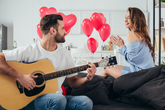 loving couple celebrating st valentine day while young man playing acoustic guitar