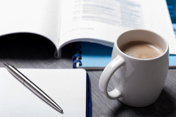 Hot coffee with blank paper note on wood background