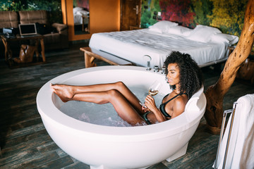 Young woman relaxing in the jacuzzi - obrazy, fototapety, plakaty