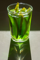 Vaso de alcohol con pomelo verde dentro