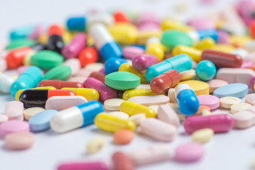 Green and yellow pills or capsules on a white background