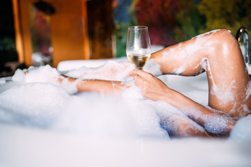 Young woman relaxing in the jacuzzi covered in foam