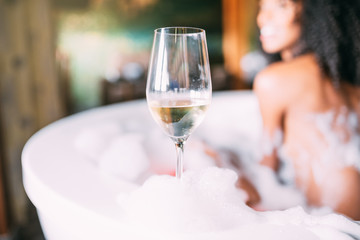 Wine glass with woman relaxing in the jacuzzi