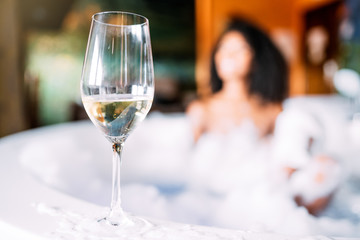 Wine glass with woman relaxing in the jacuzzi
