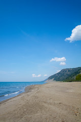 Beach, sand and sea against a bright blue background and rock