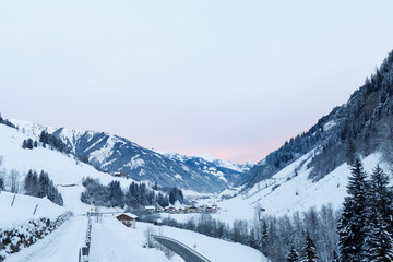 Fototapeta na wymiar orange sunrise in valley großarl, austria in winter with snow