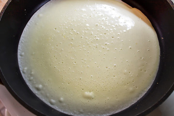 Cooking pancakes in the home kitchen. Pan with dough.