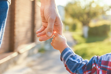 the parent holding the child's hand with a happy background