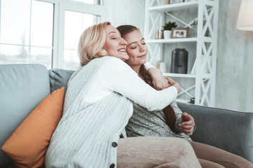 Fototapeta premium Delighted positive aged woman hugging her granddaughter