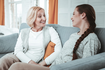 Pleasant happy girl having a conversation with her mother