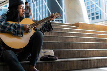 Beggars, Homeless people sitting on the stairs, Play guitar, Discouraged and desperate, ask for a...