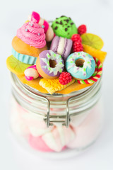Стеклянная баночка, на который декор из полимерной глины в виде пончиков с разноцветной глазурью, фисташкового мороженого, маффина или капкейка с розовым кремом, макарунов, печенья