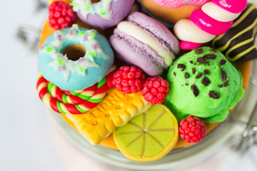 Стеклянная баночка, на который декор из полимерной глины в виде пончиков с разноцветной глазурью, фисташкового мороженого, маффина или капкейка с розовым кремом, макарунов, печенья