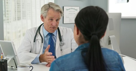 Medical doctor talking to woman patient at desk in slow motion - Powered by Adobe