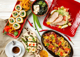 Top view flatlay japanese style business lunch including soup, salad, sushi, dessert and main meal at wooden table decorated background.