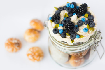 Стеклянная баночка, на который декор из полимерной глины в виде свежих ягод черники, ежевики, листьев мяты и взбитых сливок