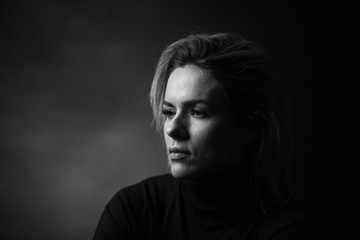 Dramatic black and white portrait of a beautiful woman on a dark background