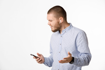 bearded businessman uses wireless headphones and smartphone