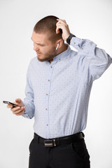 bearded businessman uses wireless headphones and smartphone