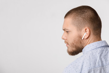 calm bearded young businessman uses wireless headphones.