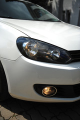 Fototapeta na wymiar headlight of the main light of the white car, close-up.