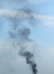 Fototapeta na wymiar Black smoke with blue sky in background