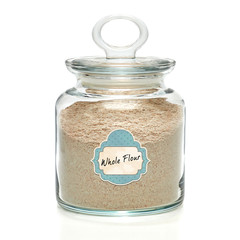 Whole flour in jar with scoop isolated on white background