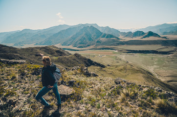 Fototapeta premium Girl tourist photographs mountain scenery. Selfies in the Altai Mountains. Chui tract, Altai. Valley Chuya.