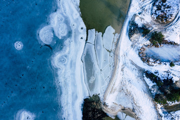 Aerial view of frozen lake. Winter scenery. Landscape photo captured with drone above winter wonderland.
