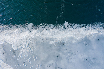 Glacier Lagoon with icebergs from above. Aerial View. Cracked Ice from drone view. Background...