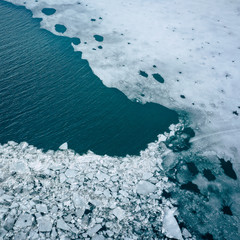 Glacier Lagoon with icebergs from above. Aerial View. Cracked Ice from drone view. Background texture concept.