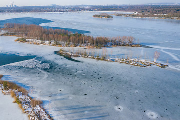 Aerial view of frozen lake. Winter scenery. Landscape photo captured with drone above winter wonderland.