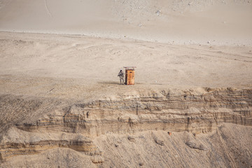 A lonely soldier stands guard, surrounded by yellow sand.