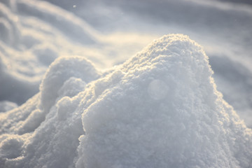 Snow snowbank on a Sunny day. Fluffy snow shimmers in the sun, abstract natural figures